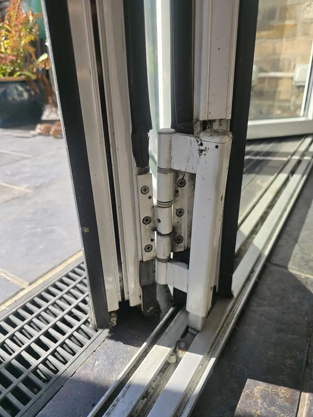 Worn hinge on an aluminium bifold door