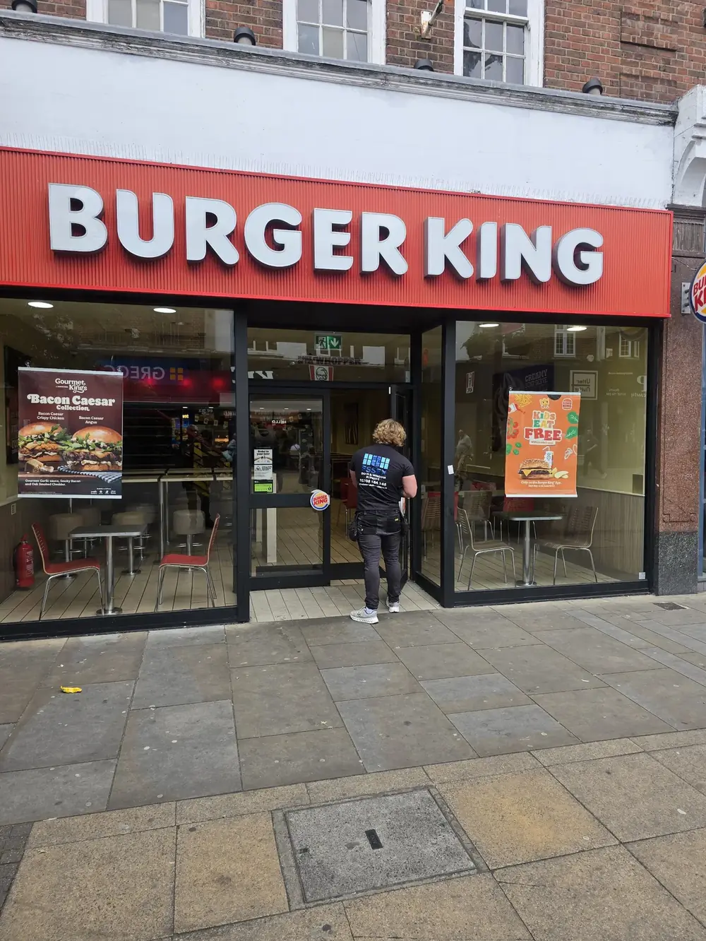 Engineer at the entrance door of a Burger King on the high street