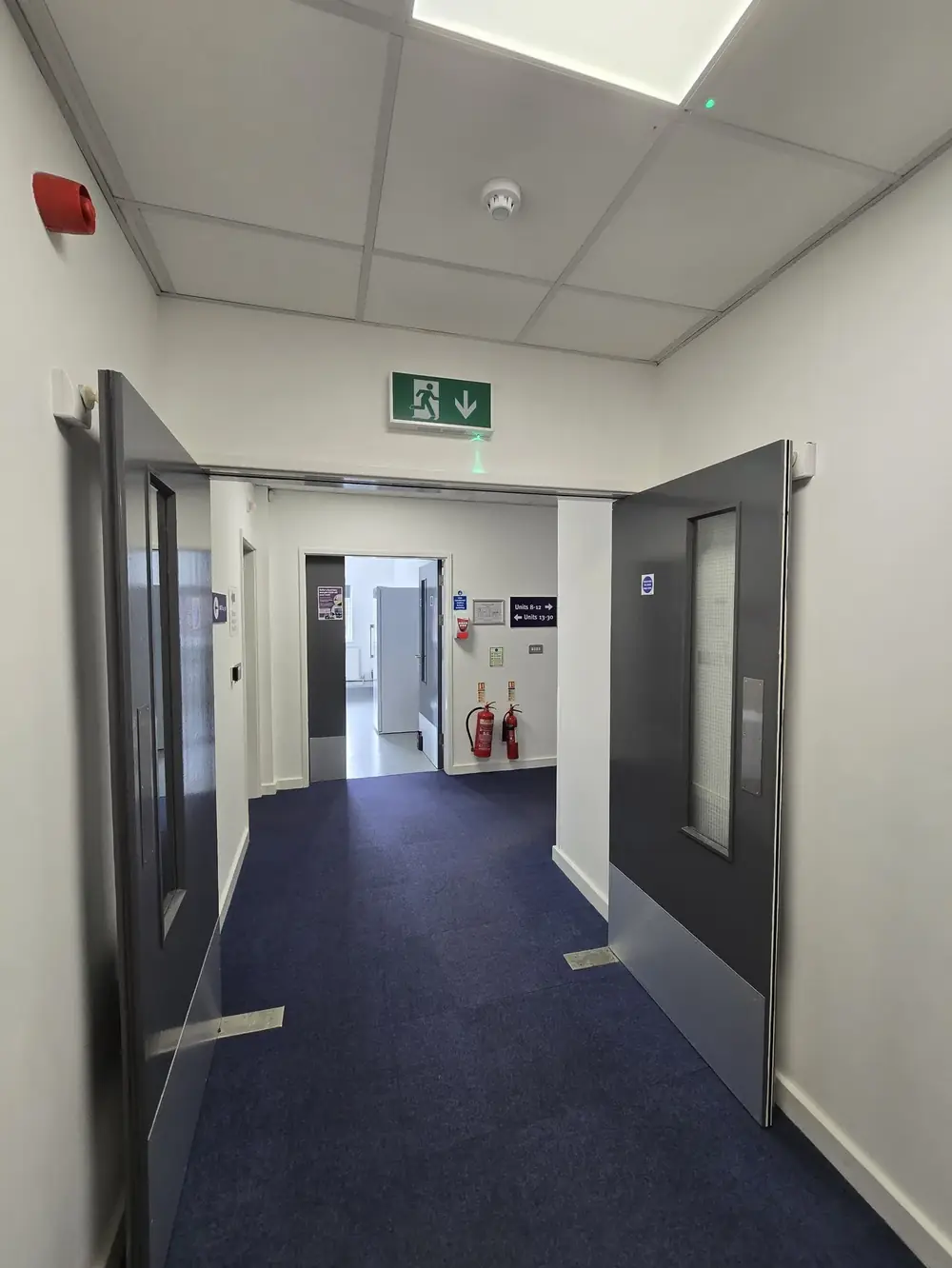Automatic fire doors held open in a business centre corridor