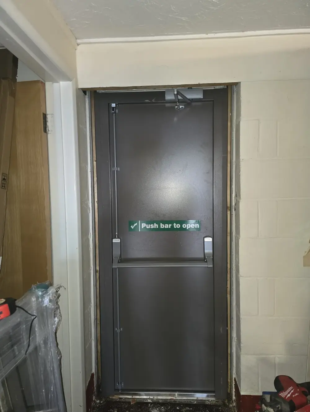 New steel fire exit door with push bar and overhead closer