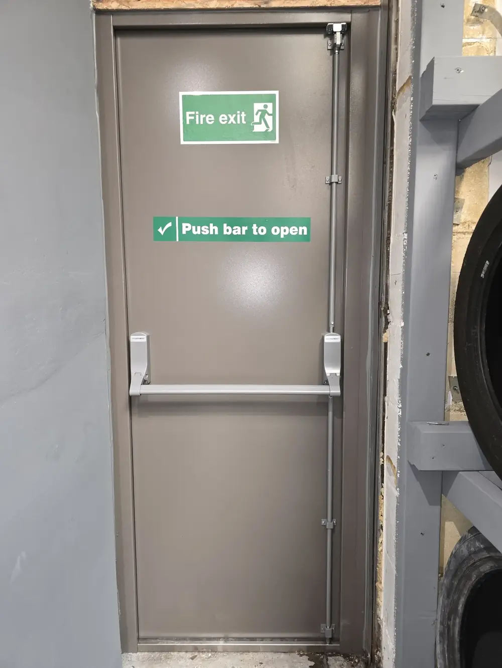 Fire exit door with panic bar at a commercial garage