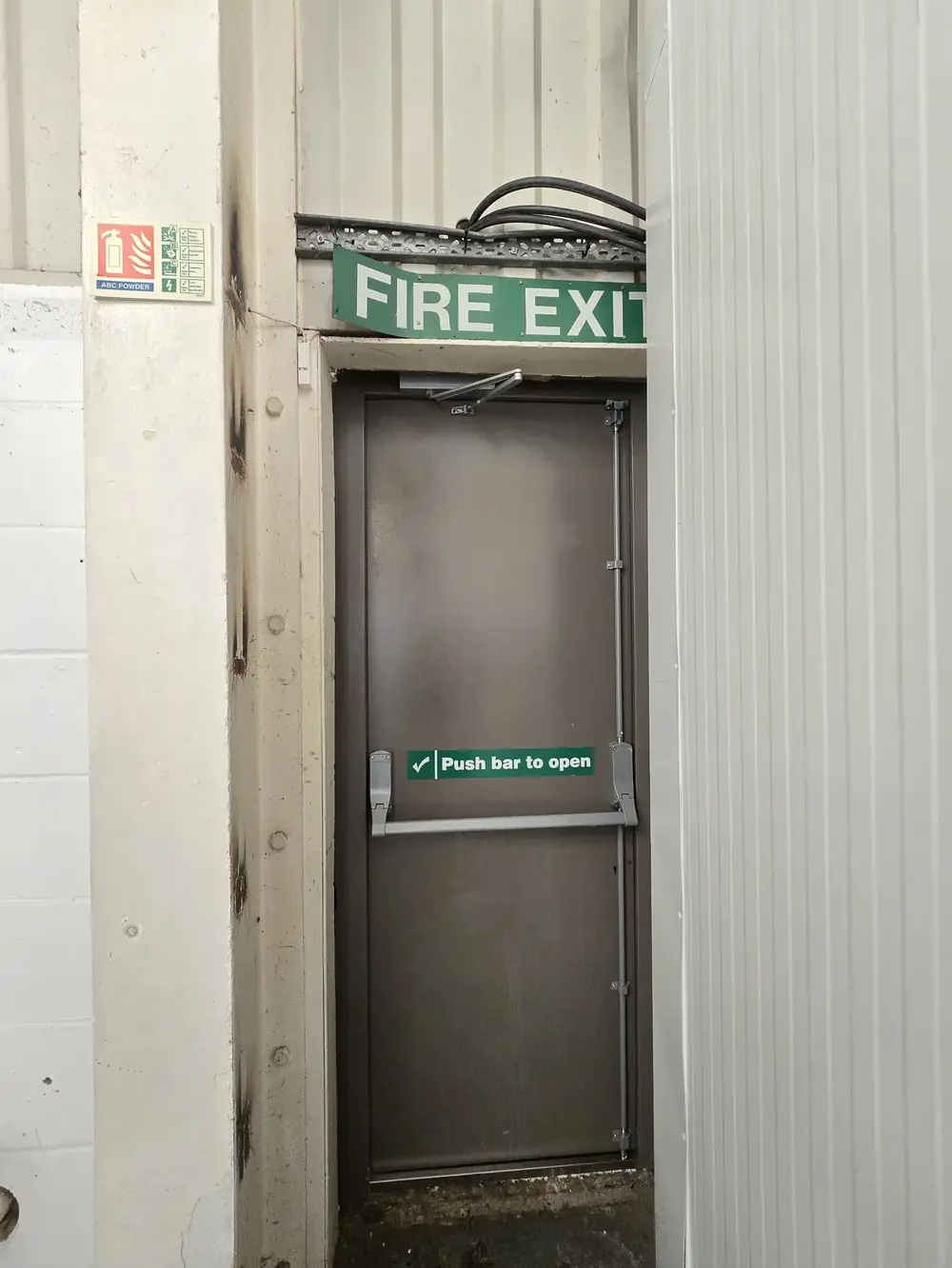 Steel fire exit door with panic bar in an industrial unit