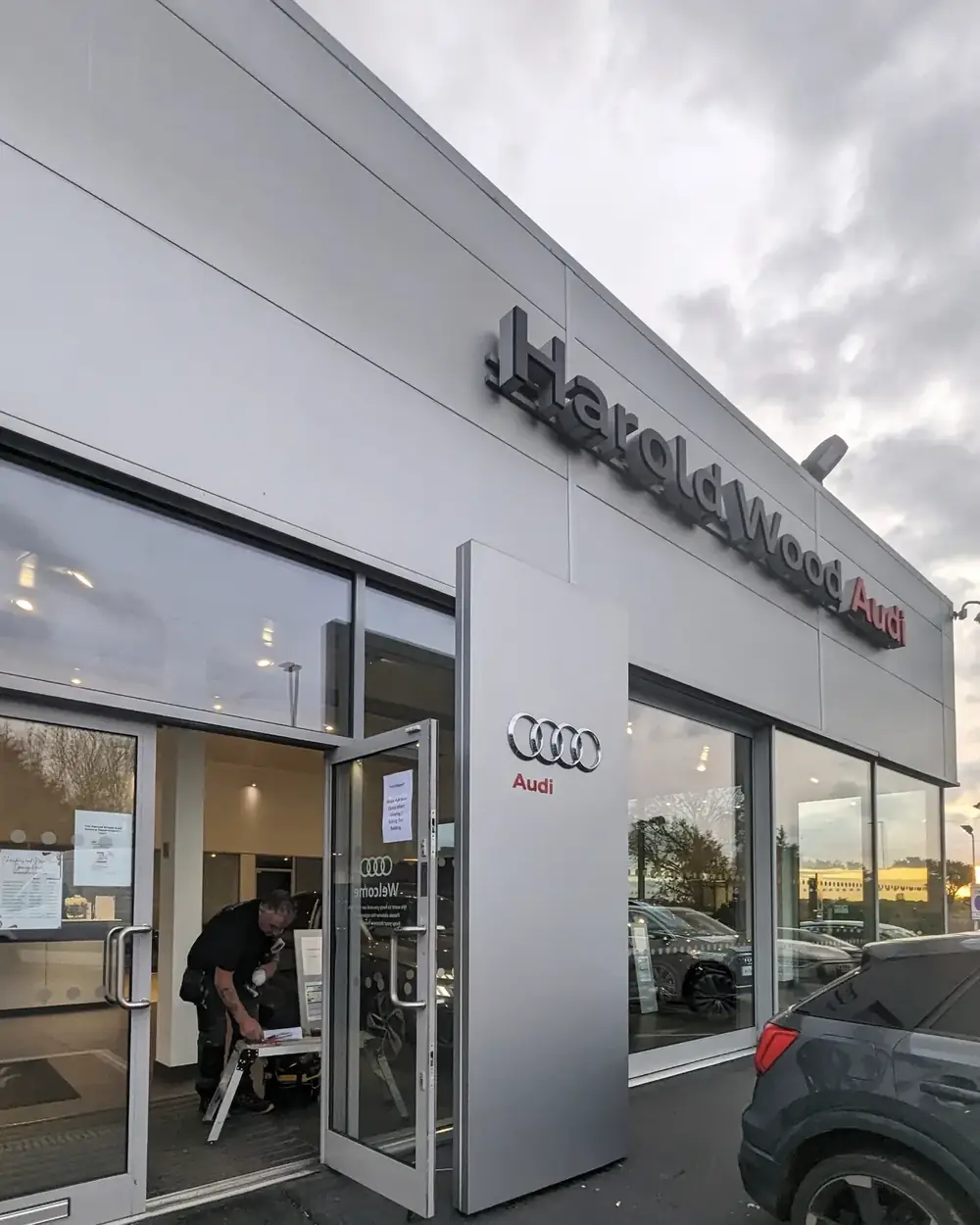 Engineer repairing the entrance door at Harold Wood Audi